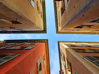 Crossroads formed by buildings, roofs of houses. Blue sky on the narrow streets of the old town in Nice, France