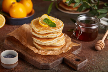 Stack of Pancakes with lemon flavor and poppy seeds, served with honey. Healthy breakfast for the family. 