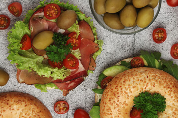 Sesame bagels with tomatoes, ham and olives	