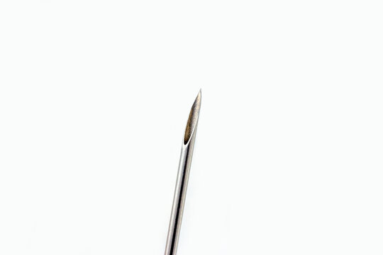 Steel medical cannula needle for injections on white background with copy space close up.