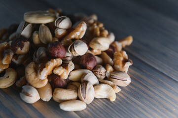 mixed nuts in a bowl on wooden table, top view with copy space.