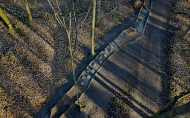 Tactile path for bare feet awakens the senses and uneven endings on the feet alternating different materials wood stone gravel sand bark in a park environment, above, aerial, above, spring, sunny