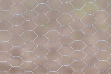 Barb wire-mesh fencekeep livestock on the farmland and shows no trespassing for unauthorized people on agricultural field or for prison and jail security against crime and escape of prisoners in jail