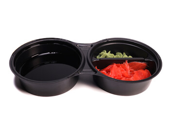 wasabi sauce, soy sauce and pickled ginger, sushi set in plastic takeout container isolated on white