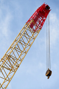 Crane and lifting hook close up against blue sky