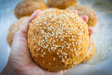 Keto Bun for burger in hand. Low carb buns baked with psyllium husk and flax seeds. Ketogenic diet...