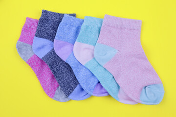 stack of colored children's socks on a yellow background
