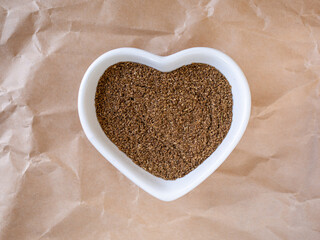 Ground cinnamon in a heart shaped white bowl