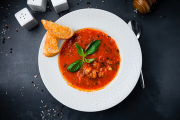 Hot tomato soup with meat, spices, basil and fried bread.