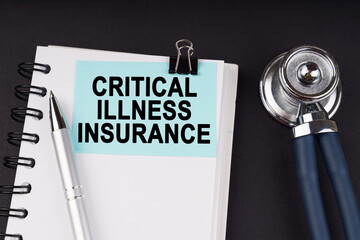 On a black surface, a stethoscope, a notebook, a pen and a blue sticker with the...