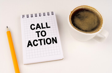 On a white surface, a cup of coffee, a pencil and a notepad with the inscription - Call to Action