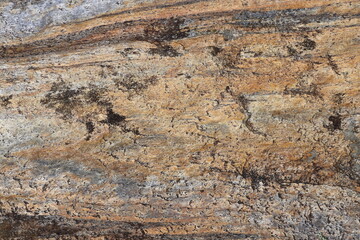Gold brown and grey stone patterns with stripes from riverbed of Vale Verzasca in Switzerland