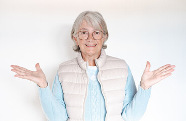 Portrait attractive senior woman in eyeglasses looking at camera gesturing with hands, isolated on white background. Facial expression, emotion, feelings, body language