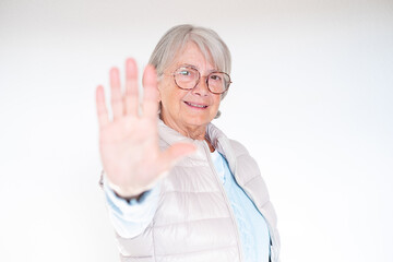 Closeup portrait headshot senior woman looking at camera, stop gesture, quiet silence isolated white background. Facial expression, sign, emotion, feelings, body language