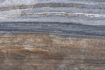 Gold brown and grey stone patterns with stripes from riverbed of Vale Verzasca in Switzerland