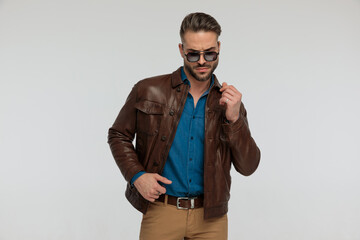 Obraz premium casual man looking down and adjusting his jacket