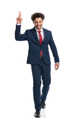 elegant young businessman holding fingers up, smiling and walking