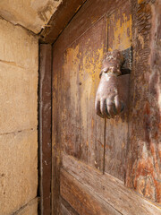 Hand door knocker on a wooden door in a village in Spain in Castilla y Leon.
