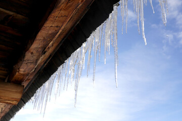 Winter icicles hanging from eaves of roof