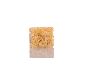 One cube of brown sugar, close-up, isolated on white.