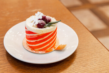 A cake with berries lays on a white saucer, close up photo