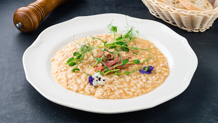 Fresh Italian risotto with parmesan, Parma ham and microgreens.