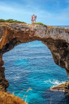 Ein verliebtes Paar l&auml;uft auf einer Felsbr&uuml;cke &uuml;ber einer Bucht bzw. Grotte, Pont natural d'Es Cal&oacute; Blanc, Mallorca, Balearen, Spanien, Europa