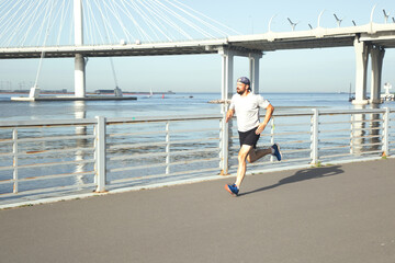 View of a running sportsman on the embankment