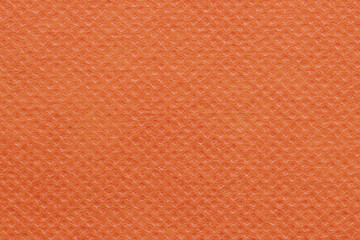 Orange non-woven polypropylene fabric texture. A piece of eco-friendly shopping bag material