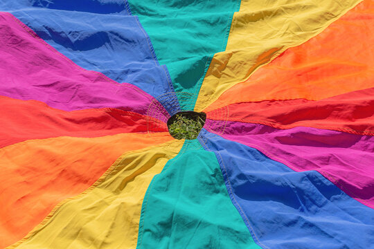 Kids play parachute for outdoor education. Rainbow colors fabric toy for childrens development games