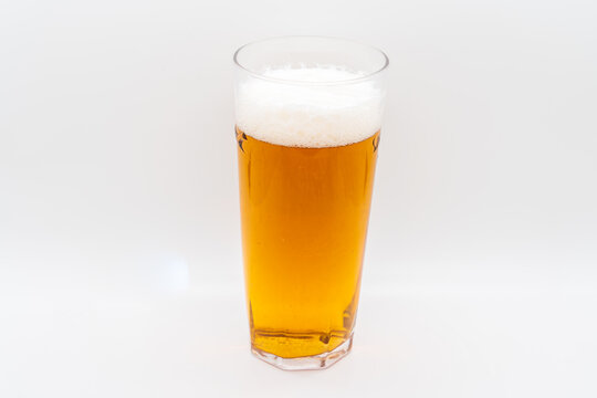 Pint of cold lager beer in a glass isolated on a whiite background