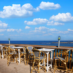Morning on the sea. Seaside outdoor empty cafe with impressive view of calm blue the Mediterranean sea