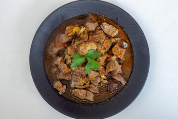 Roasted lamb liver with onions and tomatoes.