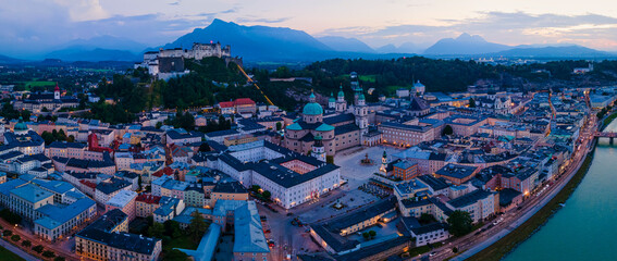 Beautiful aerial drone panorama of Salzburg city in Austria during night. View of the historic city of Salzburg and Salzach river at summer.