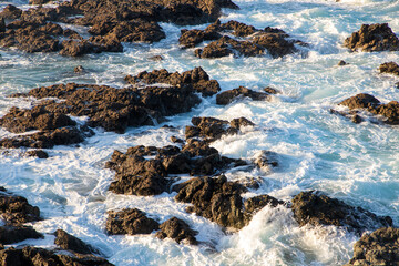 A close-up of a foamy water between rocks