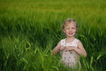 A girl in a green field of wheat
