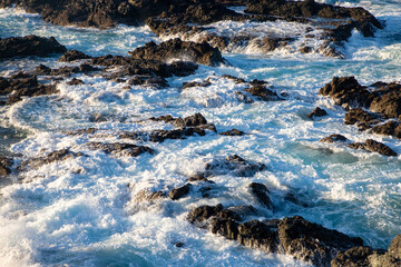 A close-up of the foaming sea water between the rocks