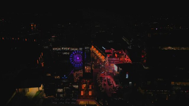 Panorama Business Mall Shopping Center in the city decorated for Christmas with a carousel and wheel at night with the lights of the city on, Timisoara Romania
