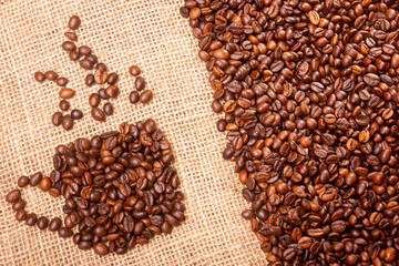 Coffee break background. Hot coffee in cup and roasted coffee beans on a wooden table. Copy space