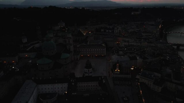 Beautiful aerial drone panorama of Salzburg city in Austria during night. View of the historic city of Salzburg and Salzach river at summer.