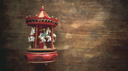 Vintage musical toy carousel with horses on a wooden table. An antique toy for a child.