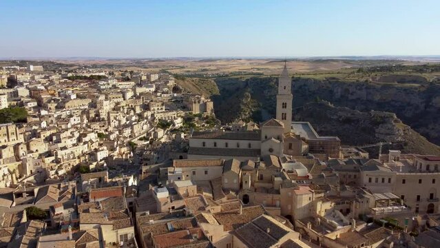 Aerial footage of Sassi di Matera UNESCO site,Basilicata, South Italy.Drone fly over Civita to Sasso Barisano district, old city houses carved in rock caves, stairs, bell tower of Cathedral from above