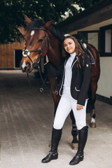 Rider woman with the horse are walking in a stable outdoors for dressage training