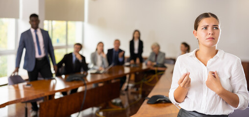 Frustrated upset millennial white female employee receiving unfair reprimand of boss in front of...