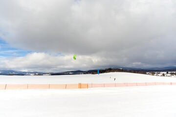 Snowkiting and rural mountain winter landscape with snow.