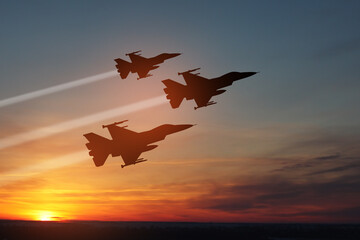 Air Force Day. Aircraft silhouettes on background of sunset. Combat flight of interceptors on a mission.