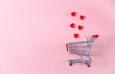 Mini cart and glass hearts on a pink background.