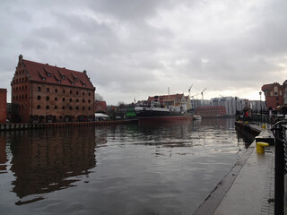 Obraz premium View of the Motlawa River to Granary Island on a cold and cloudy winter evening, Gdansk, Poland.
