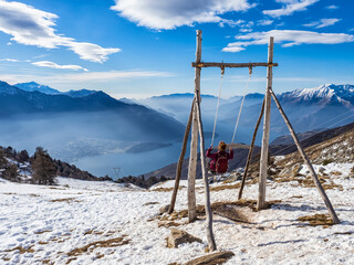 Fototapeta na wymiar Seesaw on the panoramic view of Mount Berlinghera in the alps of Lake Como