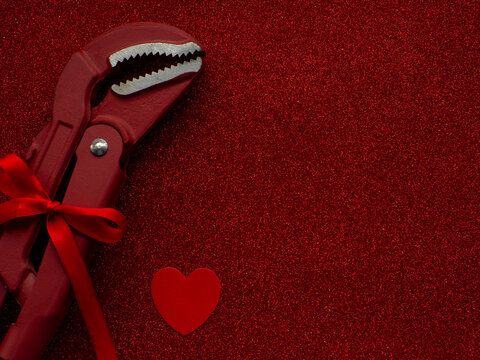 Adjustable Pipe Wrench As A Gift On Red Background With Copy Space. Construction Greeting Card For Valentines Day. Repair Home. Gifts For Lover. Buying Presents For Man. Installation Of A Water System